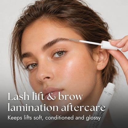 Woman applying lash and brow conditioner aftercare product to her eye area.