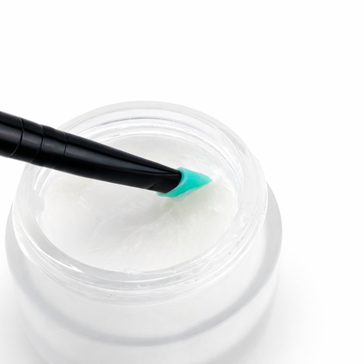 Jar of white lift &amp; lami balm with a black and green applicator on a white background